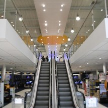 Retail mezzanine with escalator showing a large cantilever and stainless-glass balustrade