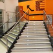 Bespoke staircase narrowing as it rises. Concrete filled treads and stainless-glass handrail partially stringer mounted and partially wall 