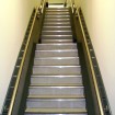 Ambulant staircase with vinyl covered flat steel treads and contrasting aluminium nosing with stringer and wall mounted 